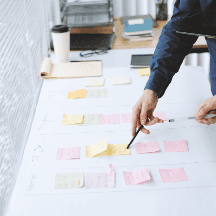 man pointing at sticky note with pen